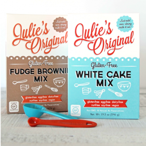 Julie's Original Gluten-Free and vegan Fudge Brownie and White Cake mix boxes with measuring spoons